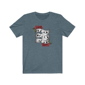 May include: A blue t-shirt featuring a graphic of a banner with the text "Cats and Tats" and red roses.
