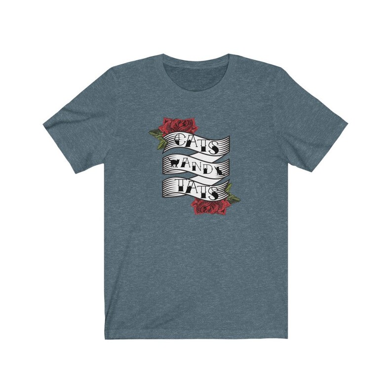 May include: A blue t-shirt featuring a graphic of a banner with the text "Cats and Tats" and red roses.