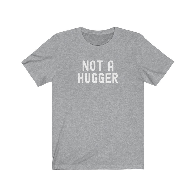 May include: A heather gray t-shirt with the text "NOT A HUGGER" printed in white.