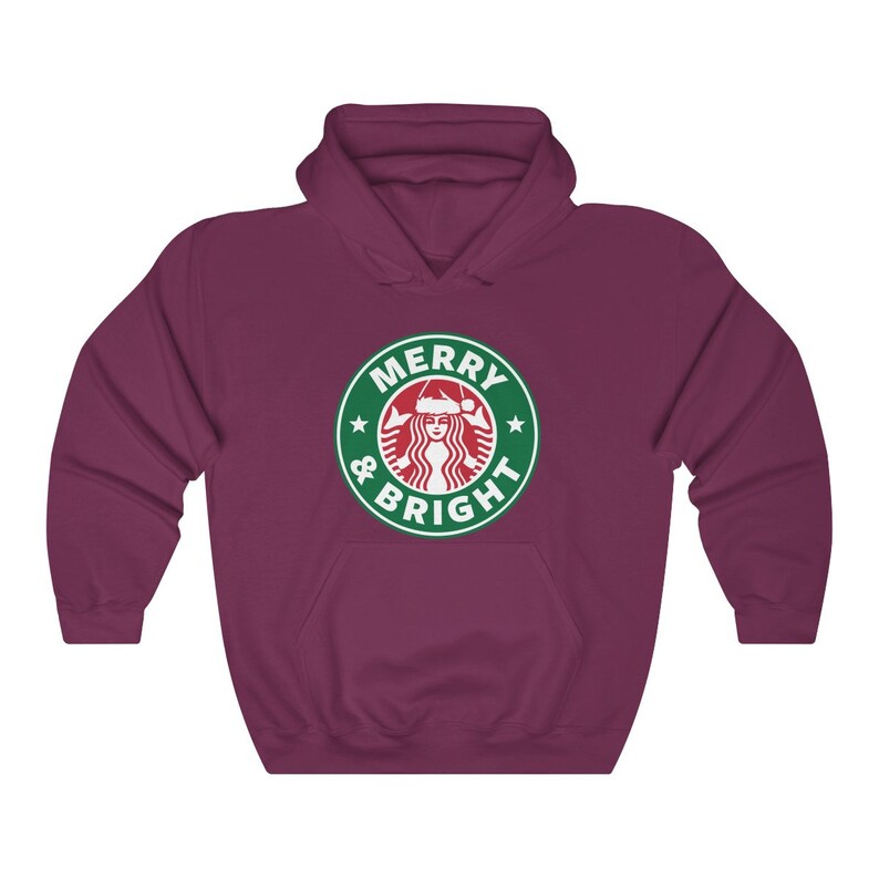 May include: A maroon hoodie with a green and white logo that says "Merry & Bright" with a stylized image of a woman wearing a Santa hat.