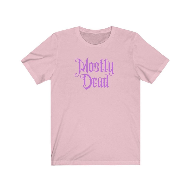May include: A pink short-sleeved t-shirt with the text "Mostly Dead" in a purple gothic font.
