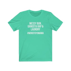 K&ouml;nnte beinhalten: T&uuml;rkisfarbenes T-Shirt mit wei&szlig;em Text "MESSY BUN, GANGSTA RAP & LAUNDRY" und dem Hashtag "#WORDTOYOMAMA". Das T-Shirt hat einen Rundhalsausschnitt und kurze &Auml;rmel.