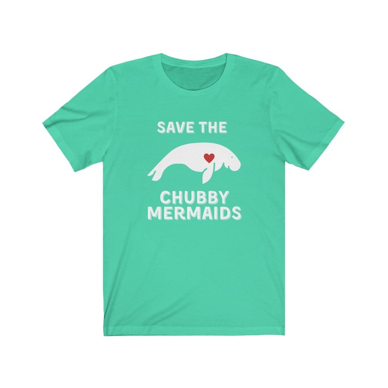 May include: A turquoise blue t-shirt with a white graphic of a manatee with a red heart and the text "Save the Chubby Mermaids".