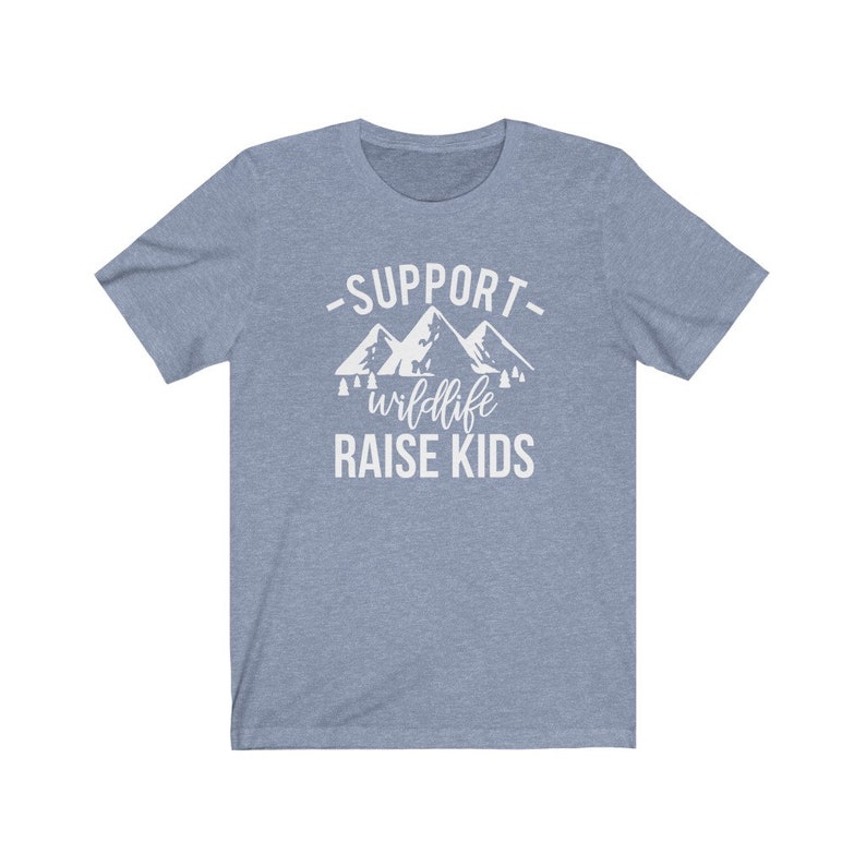 May include: A light blue t-shirt with a white graphic design that says "Support wildlife raise kids" with a mountain range illustration.