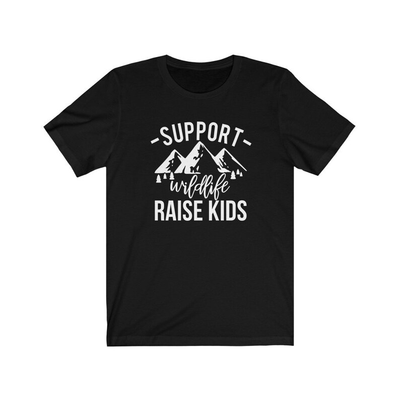 May include: Black t-shirt with white text that reads "Support wildlife raise kids" with a graphic of mountains and trees.