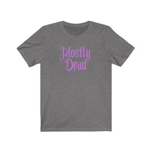 May include: A heather grey t-shirt with a purple graphic that says "Mostly Dead" in a gothic font.