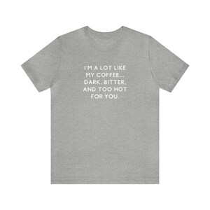 May include: A heather grey t-shirt with the text "I'm a lot like my coffee... Dark, bitter, and too hot for you." printed in white.