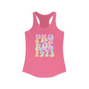 May include: Pink racerback tank top with the words "PRO ROE 1973" in a tie-dye design. The text is in a retro font, with pastel colors of blue, yellow, and pink. The tank top has a scoop neck and a racerback design.