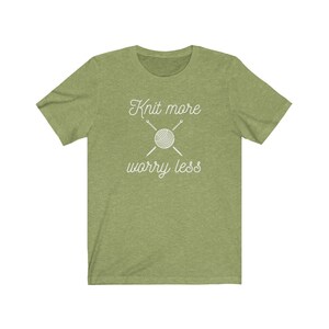 May include: Green t-shirt with white text that reads "Knit more worry less" and a graphic of a ball of yarn with knitting needles.