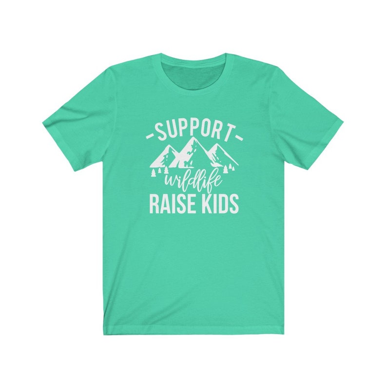 May include: A turquoise t-shirt with a white graphic design that says "Support Wildlife Raise Kids" with a mountain range and trees.