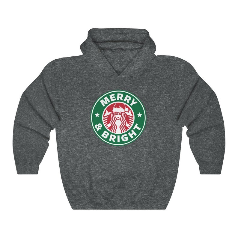 May include: A dark gray hooded sweatshirt with a green and white logo that says "Merry & Bright" with a stylized image of a woman wearing a Santa hat.