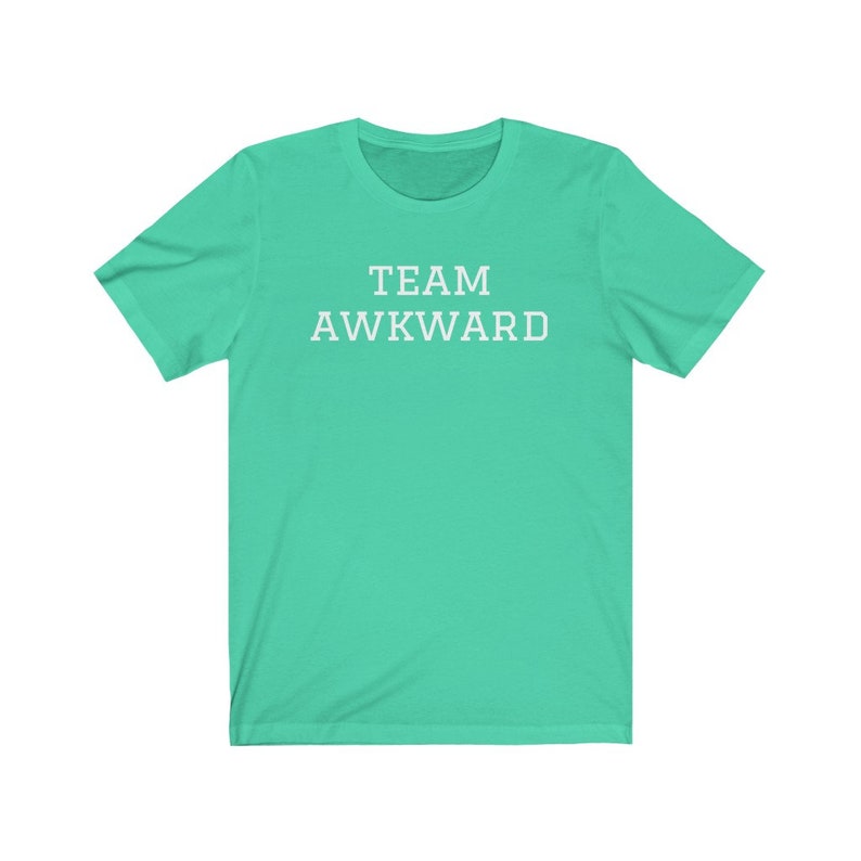 May include: A turquoise t-shirt with the text "TEAM AWKWARD" printed in white.