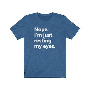 May include: A blue t-shirt with white text that reads "Nope. I'm just resting my eyes."
