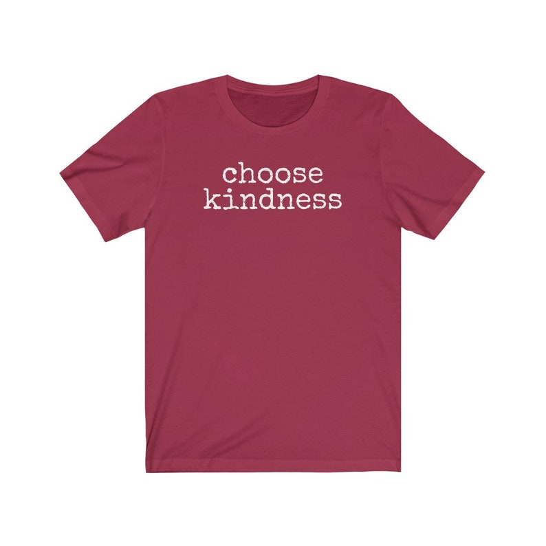 May include: A maroon t-shirt with the words "choose kindness" printed in white. The short-sleeved shirt is made of a soft material and is suitable for casual wear. The text is centered on the front of the shirt.