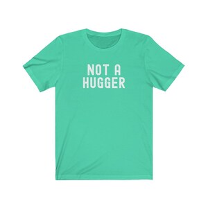 May include: A turquoise blue t-shirt with the text "NOT A HUGGER" printed in white.