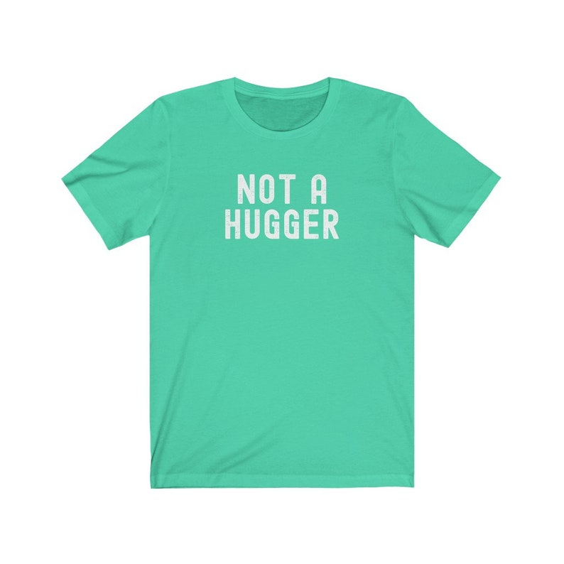 May include: A turquoise blue t-shirt with the text "NOT A HUGGER" printed in white.