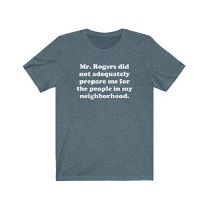 Puede incluir: Una camiseta azul oscuro con el texto "Mr. Rogers no me prepar&oacute; adecuadamente para la gente de mi vecindario."