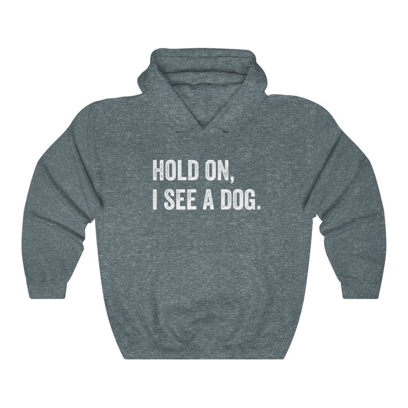 Pode incluir: Uma camisa de frio com capuz azul escuro com o texto "HOLD ON, I SEE A DOG." impresso em branco na frente.