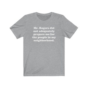Puede incluir: Una camiseta gris jaspeada con el texto "Mr. Rogers no me prepar&oacute; adecuadamente para la gente de mi vecindario."