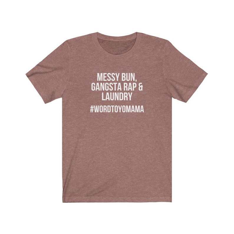 K&ouml;nnte beinhalten: Mauvefarbenes T-Shirt mit wei&szlig;em Text: "MESSY BUN, GANGSTA RAP & LAUNDRY" und dem Hashtag "#WORDTOYOMAMA". Das Shirt hat kurze &Auml;rmel und einen Rundhalsausschnitt, perfekt f&uuml;r den Alltag.
