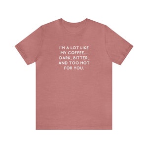 May include: A heather pink t-shirt with a white graphic that reads "I'm a lot like my coffee... dark, bitter, and too hot for you."