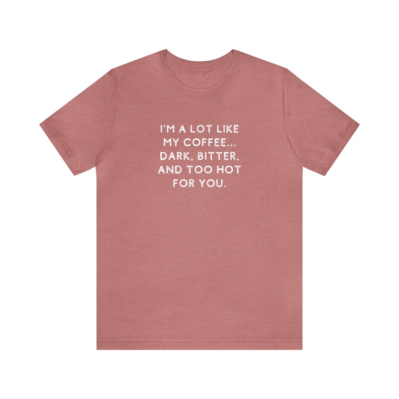 May include: A heather pink t-shirt with a white graphic that reads "I'm a lot like my coffee... dark, bitter, and too hot for you."