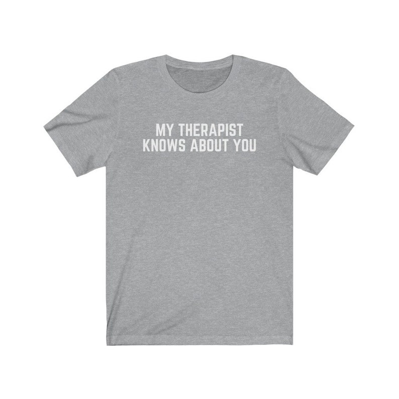 May include: A heather grey t-shirt with the text "MY THERAPIST KNOWS ABOUT YOU" printed in white.