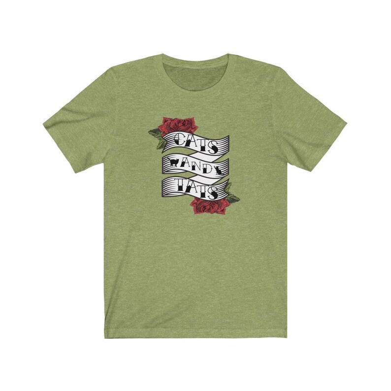 May include: Green t-shirt featuring a banner with the text "Cats and Tats" and red roses.