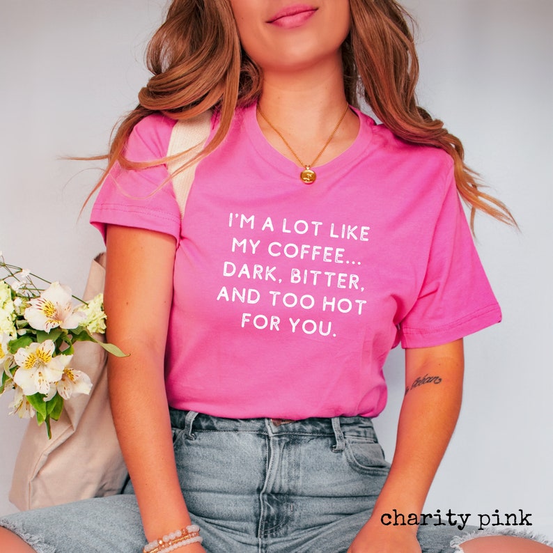 May include: A pink t-shirt with white text that reads "I'm a lot like my coffee... dark, bitter, and too hot for you."
