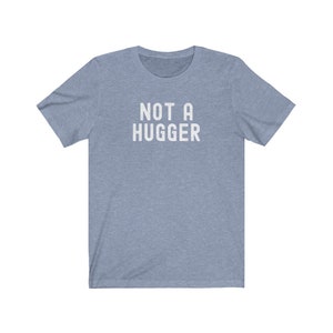 May include: A light blue t-shirt with the text "NOT A HUGGER" printed in white.