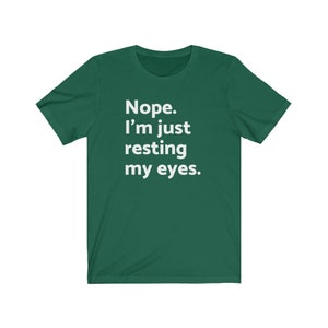 May include: A green t-shirt with white text that reads "Nope. I'm just resting my eyes."