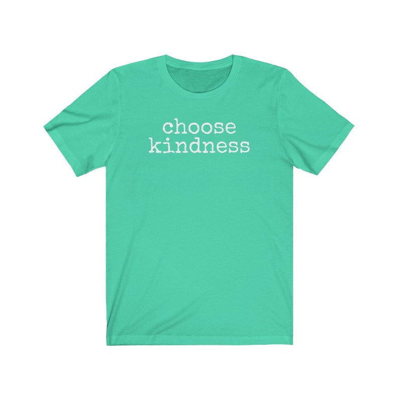 May include: A short-sleeved, teal t-shirt with the words "choose kindness" printed in white block letters across the chest. The shirt has a crew neck and is made of a soft material.