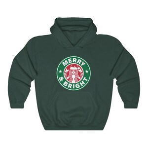 May include: A dark green hoodie with a white graphic of a Starbucks logo with a Santa hat on the mermaid and the text "Merry & Bright".