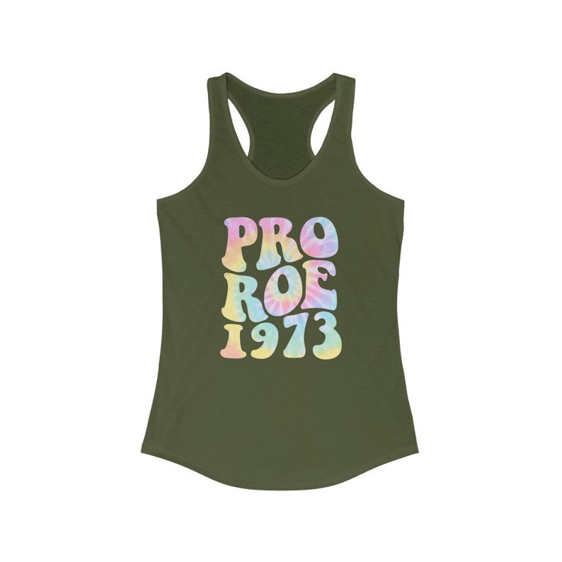 May include: Olive green racerback tank top with the words "PRO ROE 1973" in a tie-dye style font. The text is in pastel colors of pink, yellow, and blue. The tank top is made of a soft material.