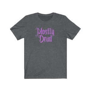 May include: A dark heather grey t-shirt with a purple graphic that says "Mostly Dead" in a gothic font.