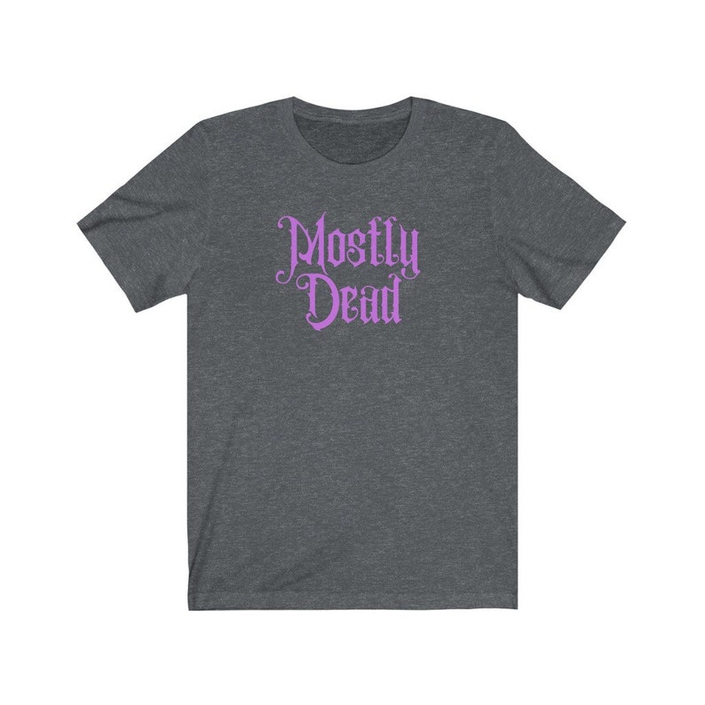 May include: A dark heather grey t-shirt with a purple graphic that says "Mostly Dead" in a gothic font.