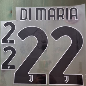 Könnte beinhalten: Schwarz-weiße Wärmeübertragungsfolie mit dem Namen "DI MARIA" und der Nummer "22". Die Nummer "22" wird in verschiedenen Größen wiederholt. Jede Zahl hat eine weiße Umrandung und das "J"-Logo.