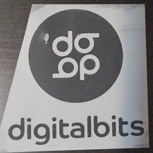 May include: A white sticker with a black circle containing the text "'do op'" and the text "digitalbits" below the circle.