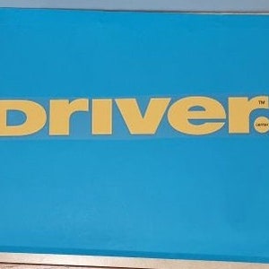 May include: A blue storage box with the word "DRIVER" in yellow letters on the front.