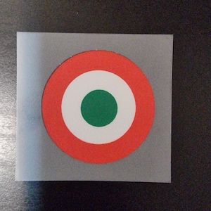 Könnte beinhalten: Eine rote, weiße und grüne kreisförmige Zielscheibe mit einem weißen Ring um einen grünen Mittelkreis.