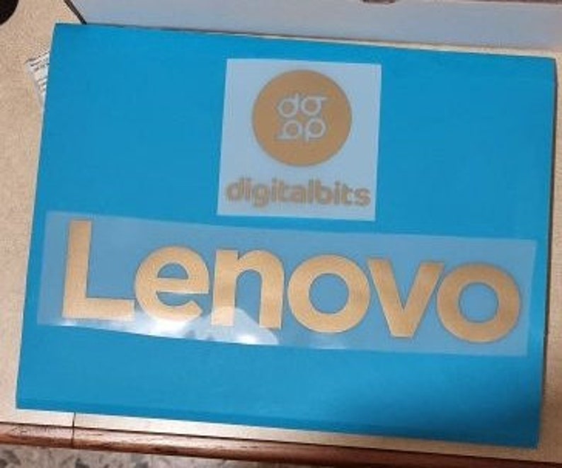May include: A gold Lenovo logo on a blue background. The logo is a stylized wordmark with the letters "Lenovo" in a bold, sans-serif font.