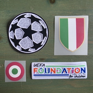 May include: A collection of four patches including a circular black and white soccer ball design, a shield-shaped Italian flag patch, a circular Italian cockade emblem, and a rectangular white patch with the text UEFA FOUNDATION for children.