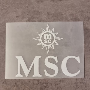 Può includere: Un adesivo bianco traslucido con le lettere "MSC" in grassetto. Sopra le lettere c'è un disegno di rosa dei venti bianco con le lettere "m" e "sc" all'interno. L'adesivo è rettangolare e poggia su una superficie grigia.