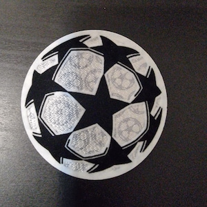 Può includere: Toppa circolare con un design a pallone da calcio in bianco e nero. La palla presenta un motivo a stella con dettagli glitterati argentati. Adatta per abbigliamento o accessori.