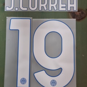 May include: White and blue football jersey numbers 1 and 9 with a blue Inter Milan logo on each number. The name J. CORREA is printed in white on a gray background.