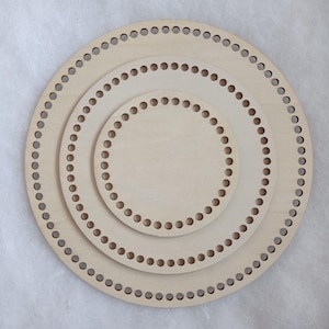 Peut inclure: Trois fonds de panier en bois non finis de différentes tailles. Chaque base ronde comporte une série de trous espacés régulièrement sur le pourtour, conçus pour le tissage ou le crochet. Le bois est de couleur claire naturelle.