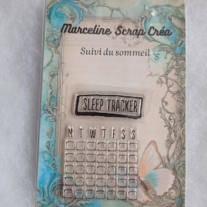 May include: Clear stamp set with a floral design border. The stamp set includes a banner that says "SLEEP TRACKER" and a calendar grid with days of the week labeled M-S.
