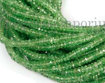 Peut inclure: Un brin de perles de pierres précieuses vertes, probablement de la péridot, de forme facetée légèrement allongée. Les perles sont enfilées pour créer un long collier ou un bracelet.