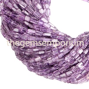 May include: A strand of purple amethyst gemstone beads, each bead is a rectangular prism shape.