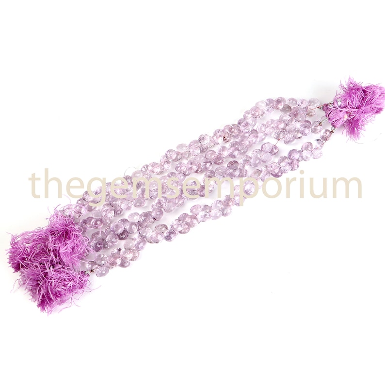 May include: Strands of faceted, light purple gemstones with matching purple tassels at each end. The gemstones are strung together, creating a delicate and elegant appearance. The image is set against a white background.